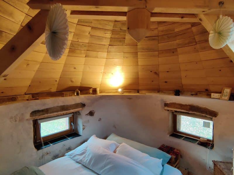 Chalet en bois avec un intérieur chaleureux et des fenêtres laissant entrer la lumière.