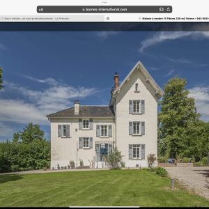 Maison de charme avec façade blanche et jardin verdoyant en Auvergne-Rhône-Alpes.