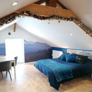 Chambre dhôtes cosy sous les combles, vue sur montagnes et décor chaleureux.