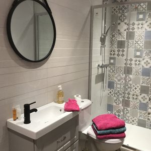 Salle de bain moderne dun hébergement insolite en Auvergne-Rhône-Alpes, avec carrelage coloré.