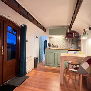 Hébergement insolite en Aquitaine : charmante roulotte avec cuisine moderne et lumière douce.