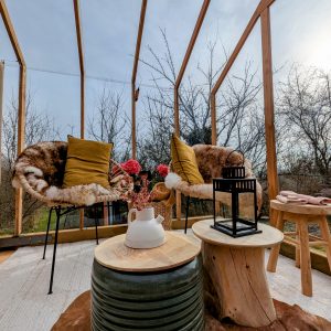 Hébergement insolite en véranda à Grand-Est, avec chaises confortables et décor floral.