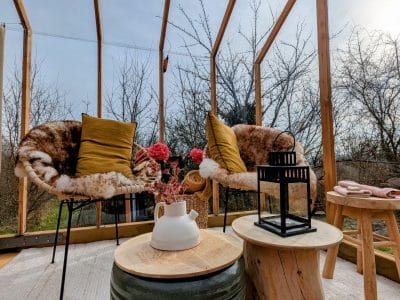 Hébergement insolite en véranda à Grand-Est, avec chaises confortables et décor floral.