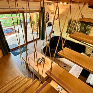 Cabane perchée à Midi-Pyrénées, avec un intérieur en bois chaleureux et un balcon.