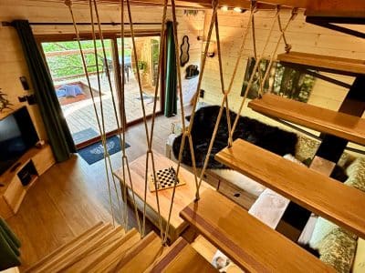 Cabane perchée à Midi-Pyrénées, avec un intérieur en bois chaleureux et un balcon.