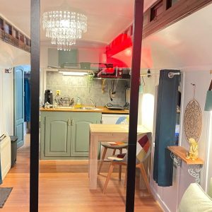 Hébergement insolite en Aquitaine : un intérieur moderne avec cuisine et lumière chaleureuse.