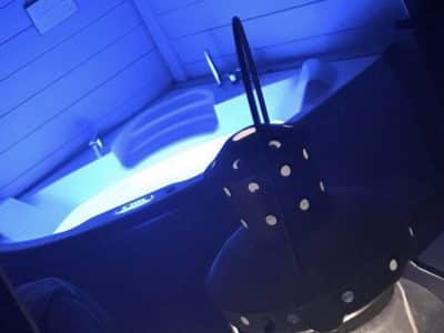 Hébergement insolite à Limousin avec jacuzzi éclairé en bleu et lanterne décorative.