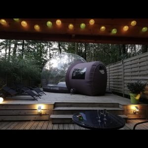 Hébergement insolite en bulle à Limousin, avec terrasse en bois et éclairage chaleureux.