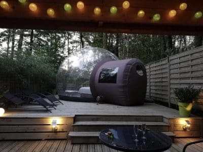 Hébergement insolite en bulle à Limousin, avec terrasse en bois et éclairage chaleureux.