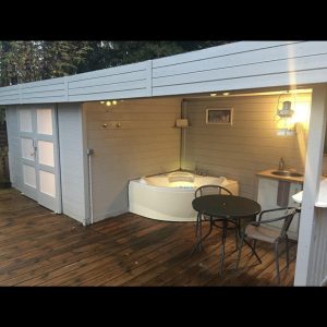 Cabane moderne à Limousin avec jacuzzi et terrasse en bois accueillante.