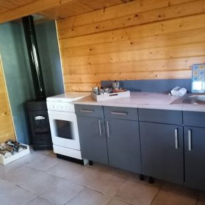 Hébergement insolite en bois à Champagne-Ardenne, avec cuisine moderne et poêle à bois.