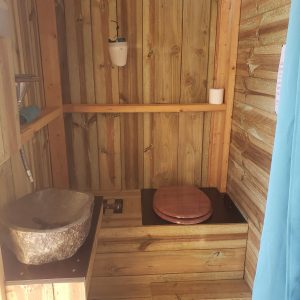 Toilettes en bois dans un hébergement insolite en Haute-Normandie, décor naturel.