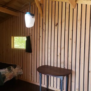 Cabane en bois à Haute-Normandie, avec murs en bois et fenêtres lumineuses.