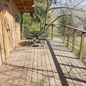 Cabane perchée en Haute-Normandie avec terrasse en bois et vue sur la nature.
