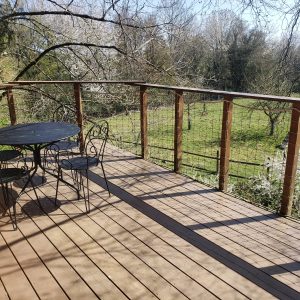 Cabane perchée en Haute-Normandie avec terrasse en bois et vue sur la nature verdoyante.