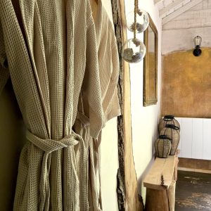 Hébergement insolite en Provence-Alpes-Côte dAzur avec peignoirs suspendus et décor chaleureux.