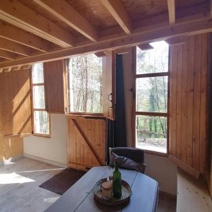 Hébergement insolite en bois à Champagne-Ardenne, avec fenêtres ouvertes sur la nature.