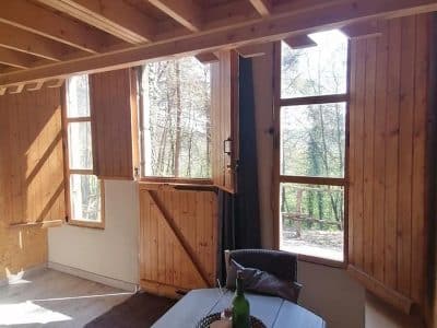 Hébergement insolite en bois à Champagne-Ardenne, avec fenêtres ouvertes sur la nature.