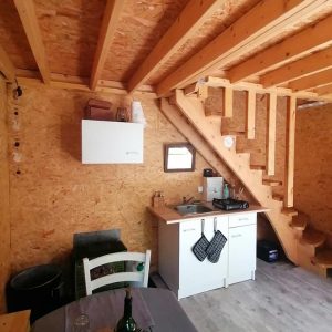 Hébergement insolite à Champagne-Ardenne : cabane en bois avec cuisine moderne et mezzanine.
