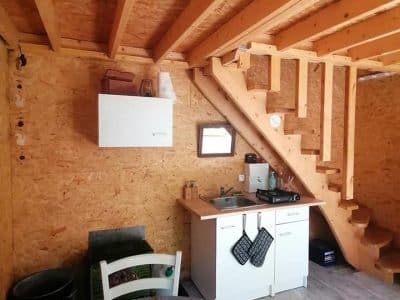 Hébergement insolite à Champagne-Ardenne : cabane en bois avec cuisine moderne et mezzanine.