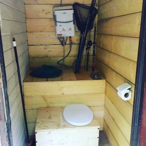 Toilettes sèches en bois dans un hébergement insolite en Champagne-Ardenne.