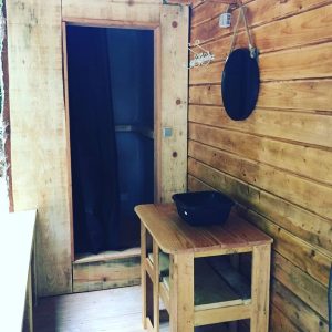 Cabane en bois à Champagne-Ardenne, avec un coin table et un miroir rond.