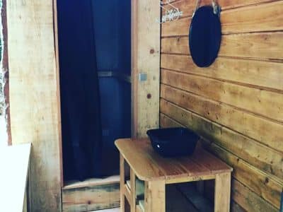 Cabane en bois à Champagne-Ardenne, avec un coin table et un miroir rond.