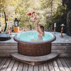 Hébergement insolite en Provence : jacuzzi en bois entouré de nature verdoyante.