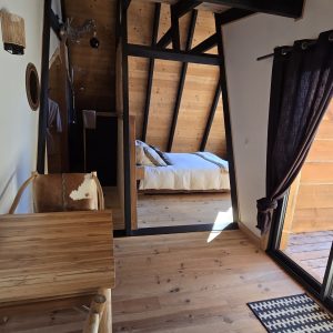 Cabane en bois avec vue sur la nature, intérieur chaleureux et lumineux.