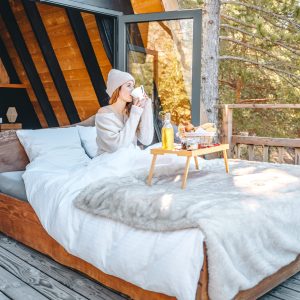 Cabane en bois avec vue sur la nature, lit douillet et petit-déjeuner sur la terrasse.
