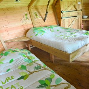 Chalet en bois avec lits confortables, décoré de motifs végétaux apaisants.