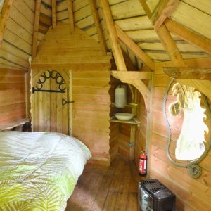 Intérieur d'une cabane en bois, avec un lit douillet et des murs en bois chaleureux.