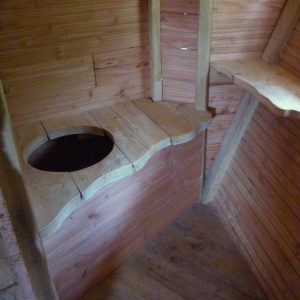 Cabane en bois avec toilettes sèches, ambiance rustique et chaleureuse. Parfait pour un séjour
