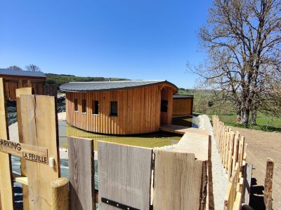 Hébergement insolite en Auvergne : cabane en bois flottant au bord dun étang.