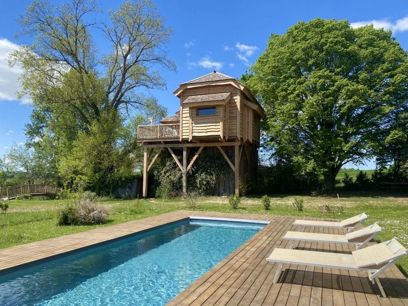 Cabane perchée à Midi-Pyrénées, avec piscine et vue sur la nature verdoyante.
