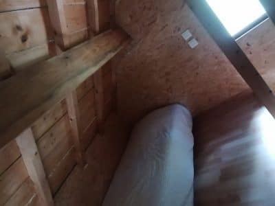 Cabane en bois à Champagne-Ardennes, avec un lit confortable sous un velux.