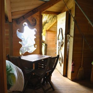 Cabane en bois avec une vue sur la nature, décorée de motifs marins et lumineuse.
