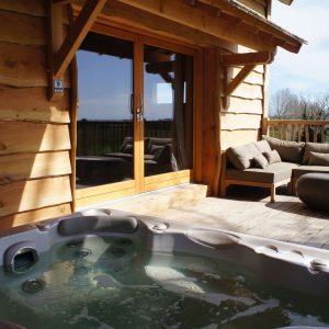 Chalet en bois avec jacuzzi sur la terrasse, vue sur la nature en Midi-Pyrénées.