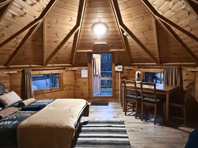 Chalet en bois avec un intérieur chaleureux et un coin repas lumineux.