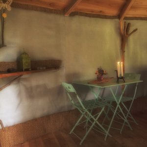 Hébergement insolite en Auvergne : une yourte avec table verte et bougies.