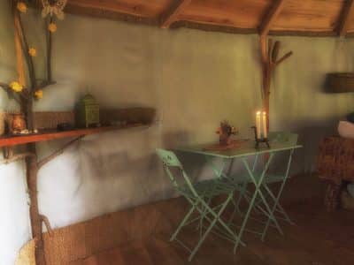 Hébergement insolite en Auvergne : une yourte avec table verte et bougies.