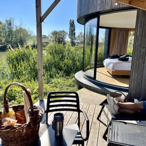 Hébergement insolite en Auvergne-Rhône-Alpes, avec vue sur la rivière et terrasse en bois.