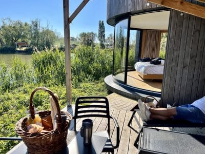 Hébergement insolite en Auvergne-Rhône-Alpes, avec vue sur la rivière et terrasse en bois.