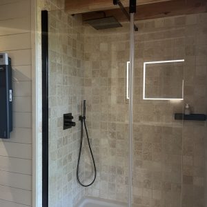 Douche moderne dans un hébergement insolite en Midi-Pyrénées, style épuré et lumineux.