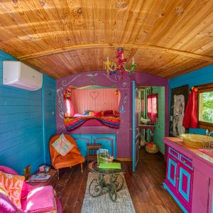 Charmante cabane colorée avec un intérieur en bois, décorée de manière ludique et accueillante.