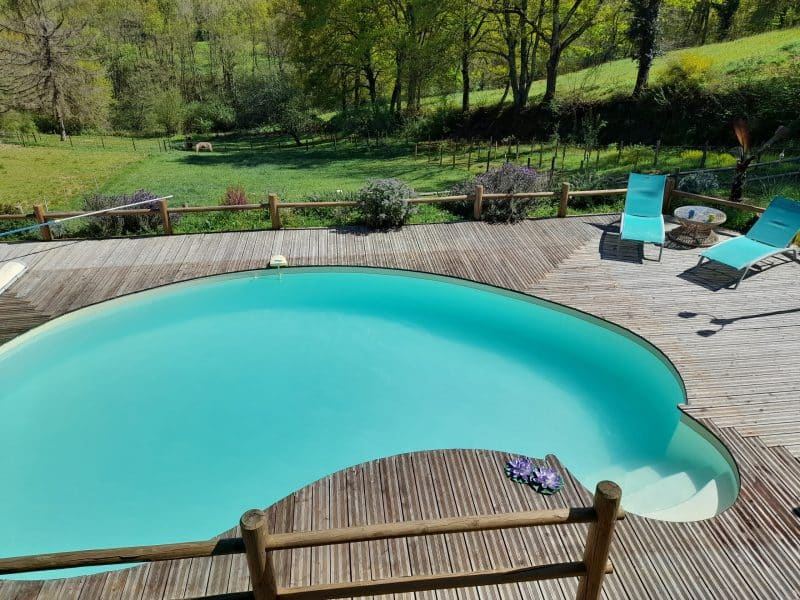 Charmante villa avec piscine turquoise entourée de verdure paisible.