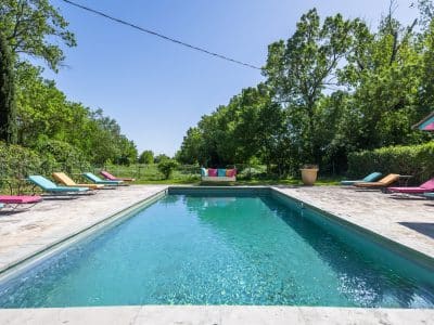 Une villa avec piscine, entourée de verdure, idéale pour des vacances relaxantes.