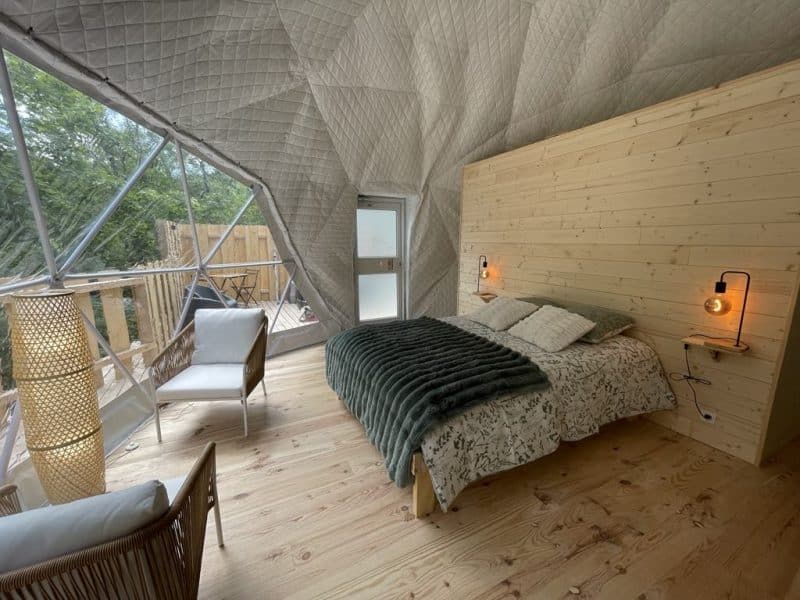 Chalet moderne en bois avec lit douillet et décoration chaleureuse.
