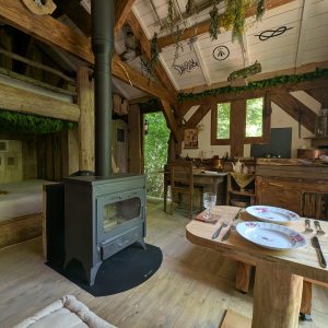 Cabane en bois avec poêle à bois, décor rustique et ambiance chaleureuse. Parfait pour se
