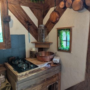 Cuisine rustique dans un hébergement insolite, avec des éléments en bois et des ustensiles en